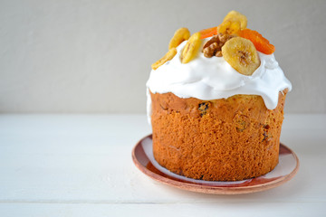 Traditional Easter cake with icing and dried fruit on top. Paska or kulich sponge cake.