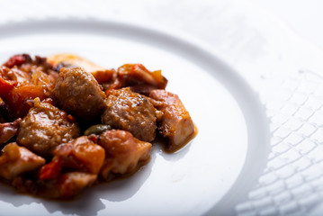 albóndigas con pulpo y patatas en salsa servidas en un plato blanco