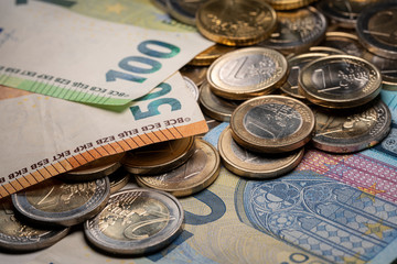 Twenty Euro bill with coins on top- Euro crisis after recession in Europe.