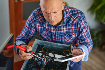 Computer repair. Computer technician working on a personal computer.