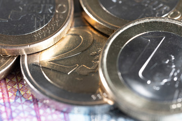 Two euro and one Euro coin closeup on top of a 20 euro bill. European money currency