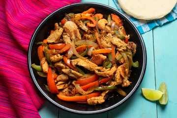 Mexican chicken fajitas on turquoise background © Guajillo studio