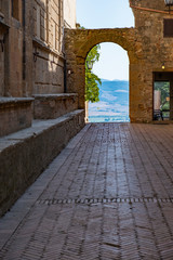 arch on narrow street and viewpoint in Tuscany on a sunny summer day