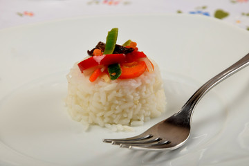 white rice with vegetables on a white plate as a side dish