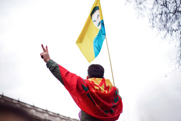 kurdish activist waves flags and makes victory gesture