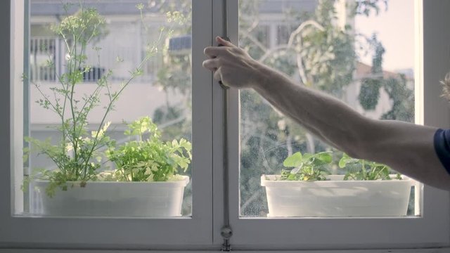 Closing a window. mans hand shutting the glass window