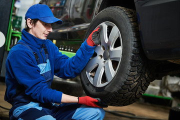 Auto service. Worker screwdriving an automobile wheel. Break maintenance or tyre replace