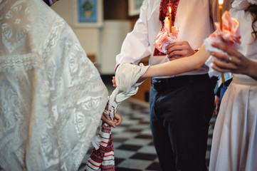 Hands of bride and groom tied Wedding towels. The priest binds the bride's hand towel. hands of...