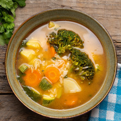 Vegetables soup with rice on wooden background