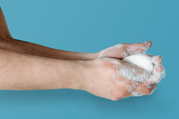 Fototapeta premium Washing hands with soap. Medical and pharmaceutical concept. Protection against viruses, bacteria, germs. Washing hands with antibacterial soap, getting rid of dirt, fighting an epidemic.