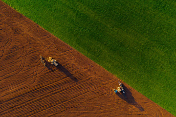 Harvesters working in the field at spring and plowing the field. Sowing work