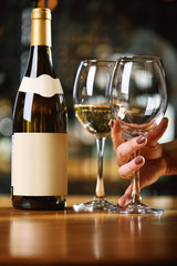 A bottle of wine and glasses on the table, against the background of a wine shakafa. Serving and serving wine. Winemaking concept, copy space.