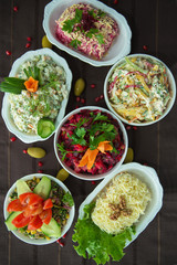 Diet salad with beets . Capital salad . Potato salad . coleslaw salad . set with different salads . Salad ham, orange pepper, mushrooms, pickles, white sauce, on a white bowl.