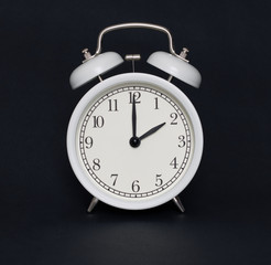 Old-style alarm clock, black and white, it's two o'clock.