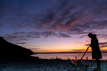 woman tending fire on Arran