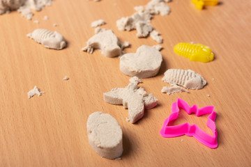 Fototapeta na wymiar kinetic sand on the table. bright multi-colored molds. close-up