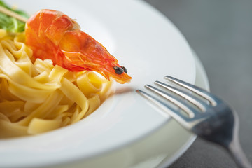 close up view to shwimp and italian pasta with fork