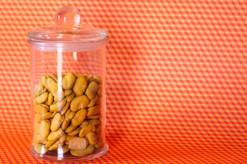 Broad beans in a jar on colorful patterned background