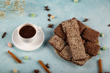 Bitter chocolate bars with anise and cinnamon aroma with a cup of tea on the blue table