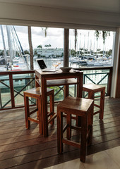 Laptop computer on a wooden table with a blurry marine background