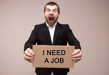 concept unemployment and coronavirus a man in black suit is holding a cardboard tablet with the...