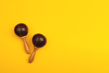 Two mexican maracas isolated on yellow background. Traditional folk musical instruments. Elements of national culture. Flat lay. Latin music.
