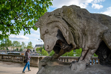 Lion sculpture roaring at a Person walking by, Park of Louvre Palace, Paris/Europe