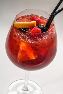 Cocktail In A Glass Goblet With Orange, Raspberry And Blackberry