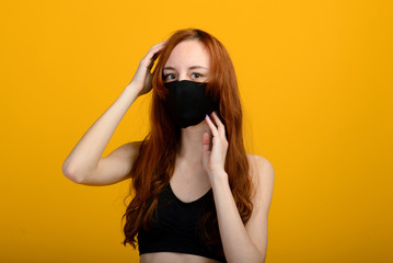 Portrait of a girl in a mask, which puts on a rubber glove. Yellow background.