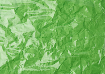 Fototapeta premium texture of a transparent stretching plastic film for packaging products on a green background