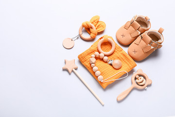 Set of baby shoes, toys and accessories on grey background. Newborn stuff. Flat lay, top view