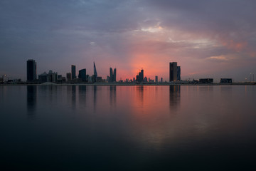 Obraz premium Bahrain skyline at sunset with reddish overcast sky, HDR