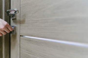 The woman closes the lock of the door with a key, a close-up. Home protection and safety