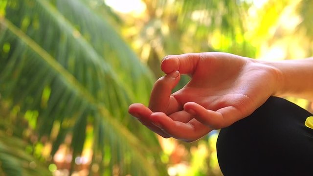 young woman doing yoga namaste munda hands pose outside in natural environment