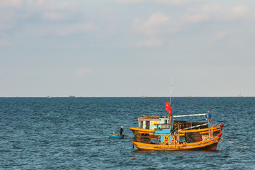 Fototapeta na wymiar 01.05.2015, Phan Thiet, Vietnam. brightly colored fishing boat sailing along the shore on background of horizon line.