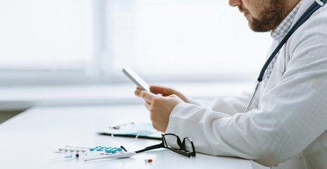 Young handsome doctor in gloves with patient online consultate