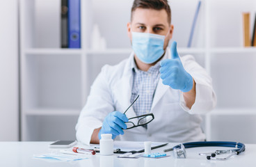 Happy man doctor in cabinet with good finger sign