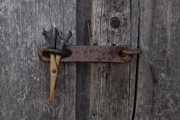 Old wooden board door with a key with scissors