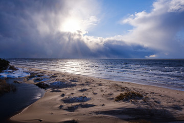 The coast of the Baltic Sea with waves and blue skies with white clouds