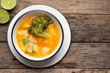 Vegetables soup with rice on wooden background