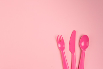 Children's plastic tableware on a pink background