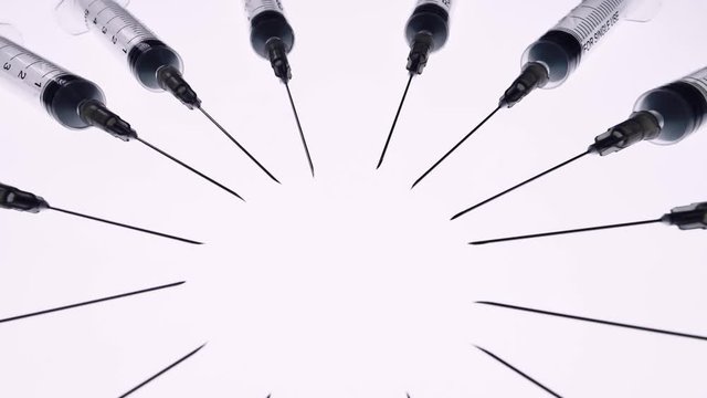 A lot of syringes rotate around on a white background. Concept Of Medicine. 