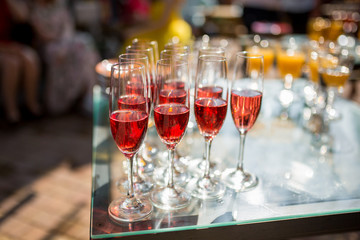 Glasses of wine on a tray under the sunlight