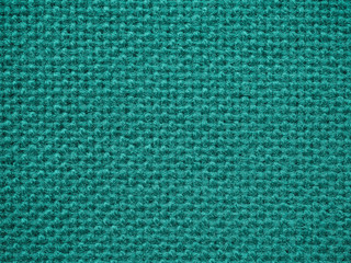 Close-up of teal fabric textile texture, background and wallpaper. The texture of teal fabric knitted carpet textile upholstery of furniture. Surface of fleece towel. High-quality macro photography.