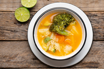 Vegetables soup with rice on wooden background