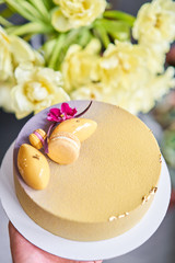 Mousse dessert covered with yellow velour. Modern european cake. Sweet dessert and tea party. French cuisine. Flowers theme. Copy space