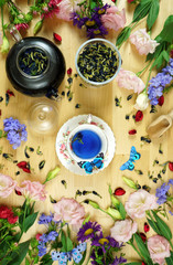 Premium Blue Butterfly Pea Flower herbal tea is a caffeine-free herbal tea beverage made from the infusion of the flower petals of the Clitoria ternatea plant. Creative layout flat lay.