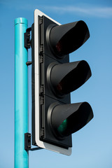 Low angle view of UK traffic lights against a clear blue sky.