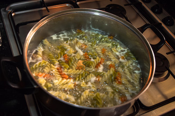 Pot cooking pasta with shape of screws. In the kitchen making sp