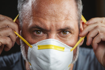 Old man wearing an anti virus protection mask to prevent others from corona COVID-19 and SARS cov 2...